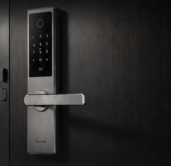 Stainless steel smart lock installed on a dark room door with drawings nearby